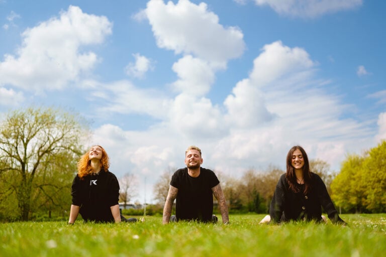 Three people enjoying a sunny day in park.